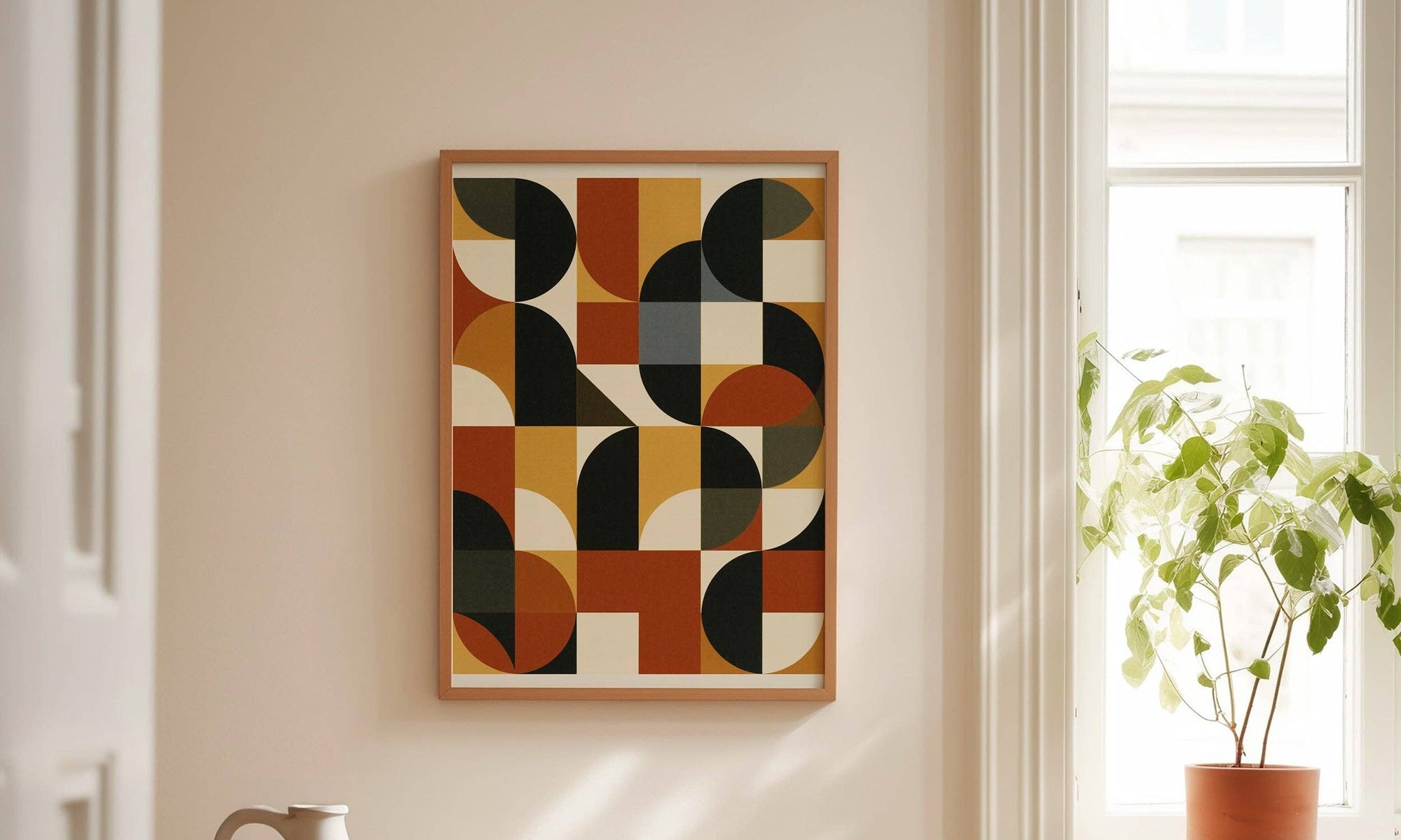A Forma Art Studio Kiln print in a natural oak frame, hung in a sunlit entryway