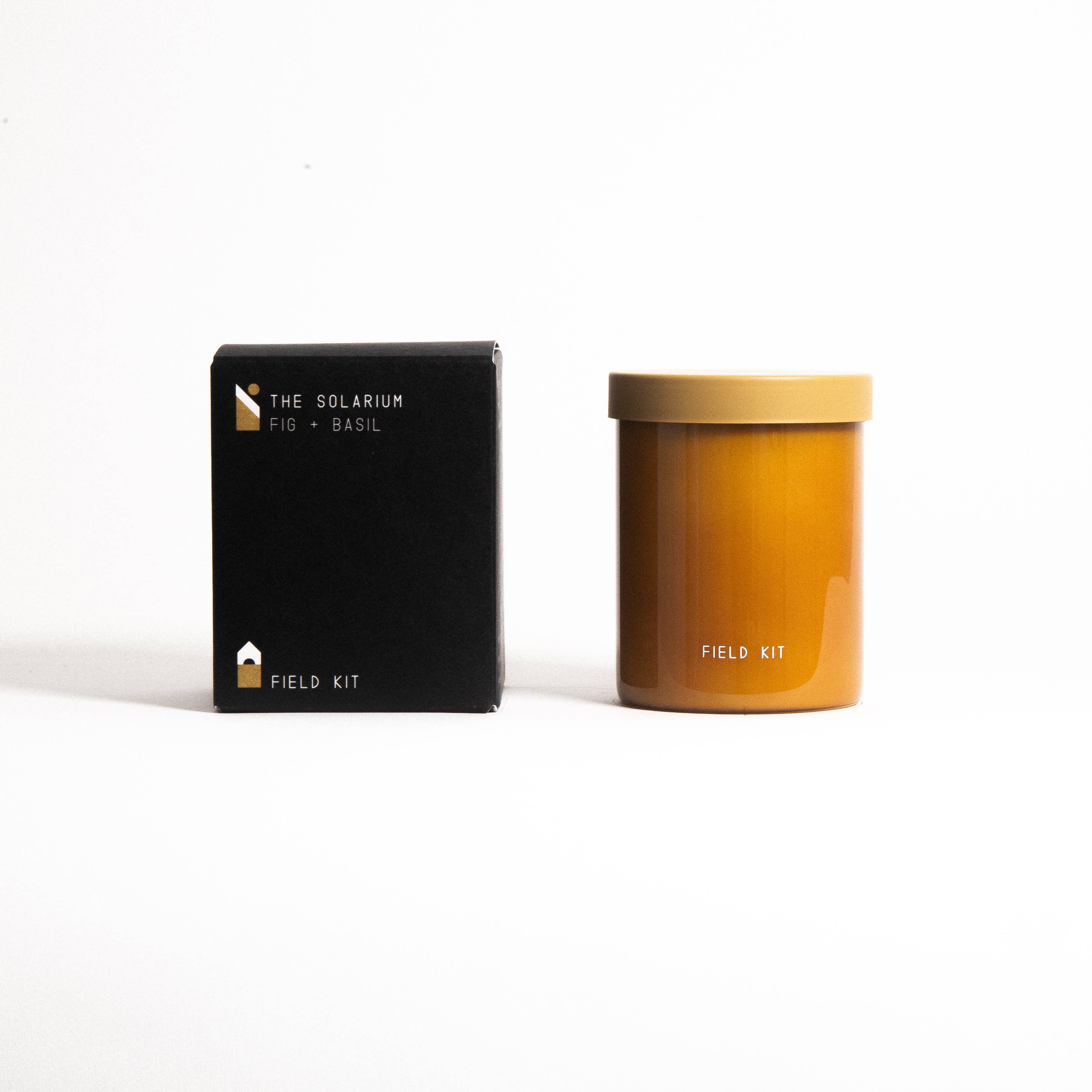 The Solarium Candle in an amber glass jar with its printed box