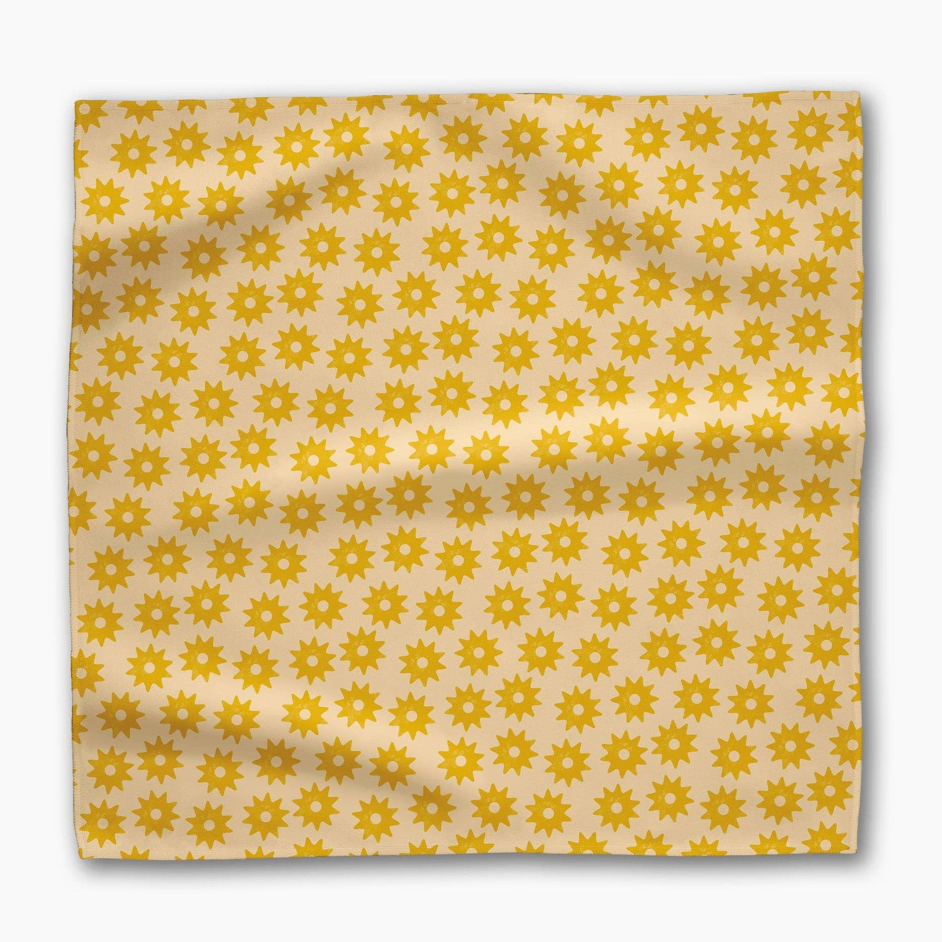 Single Sunny Sun napkin laid flat, rows of golden suns across a butter-yellow ground