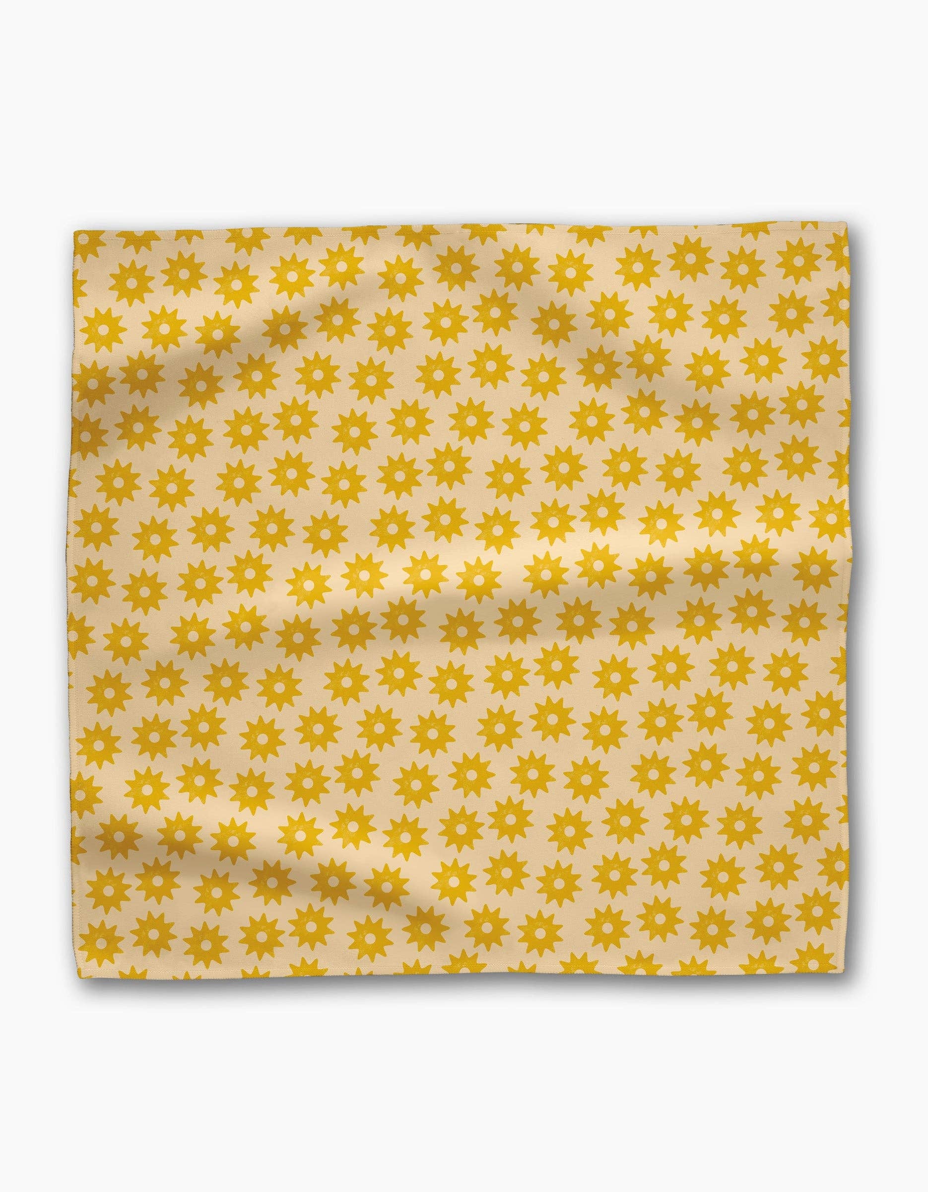 Single Sunny Sun napkin laid flat, rows of golden suns across a butter-yellow ground