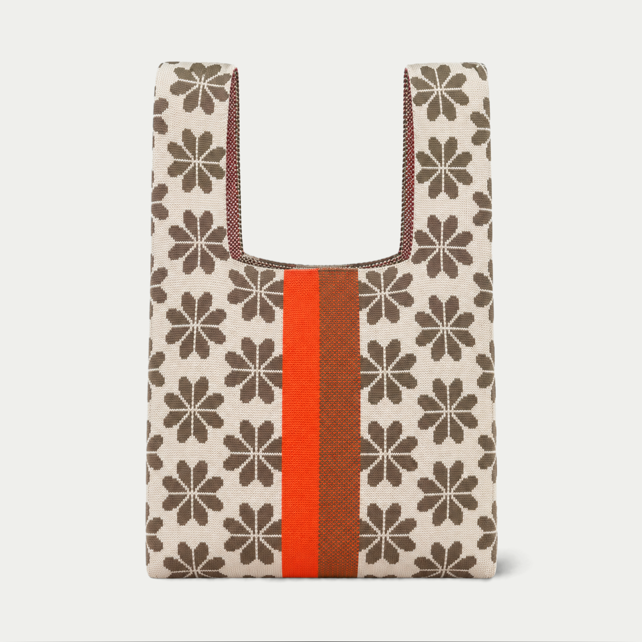 Tan knitted tote bag with a brown floral repeat pattern and a vertical orange and rust stripe