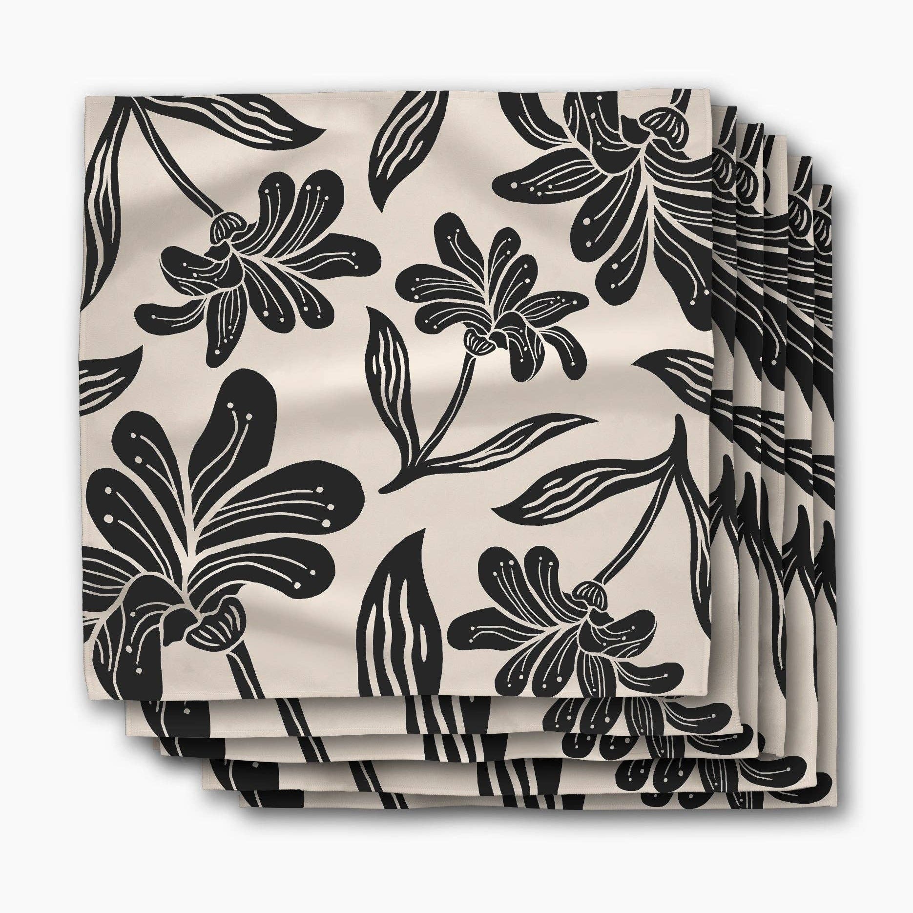 Stack of Giant Lush Floral dinner napkins, oversized black brushstroke flowers on a cream ground