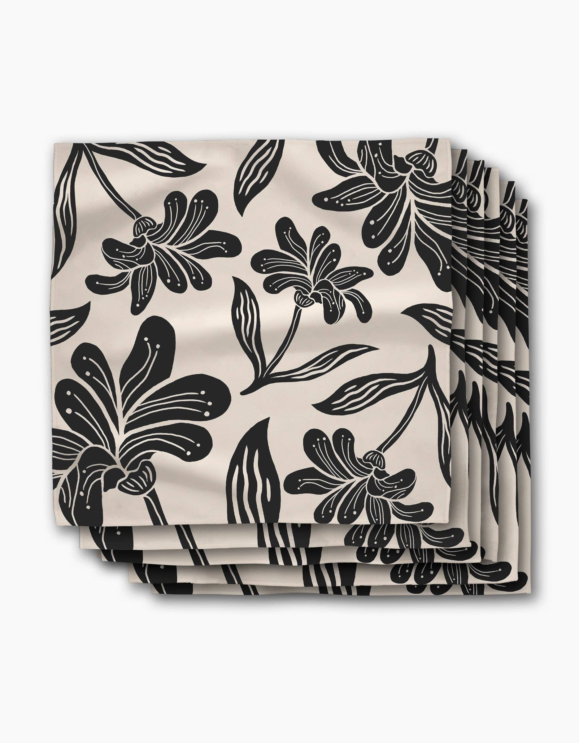 Stack of Giant Lush Floral dinner napkins, oversized black brushstroke flowers on a cream ground
