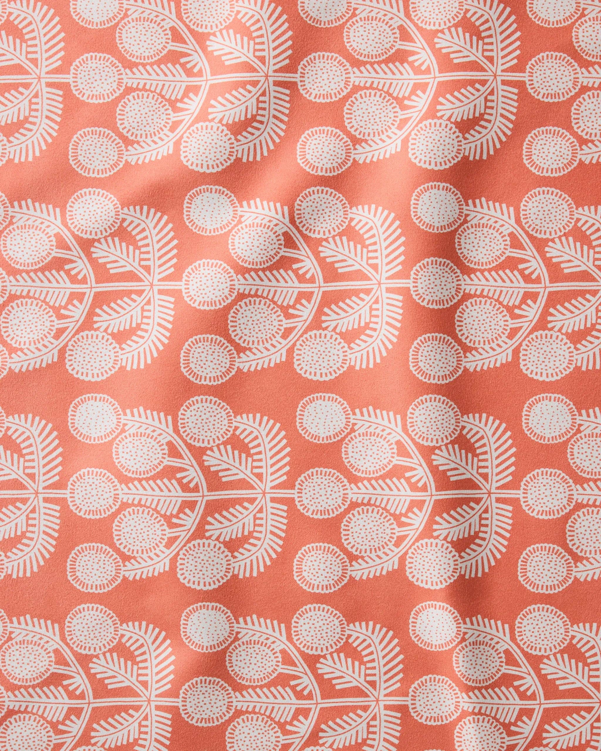 Close-up of the Graphic Daisies print, white daisy sprigs on a coral ground