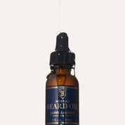 Close-up of the beard oil dropper with a strand of oil drawn from the bottle