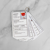 The full deck fanned open on its metal ring, showing the Paper Plane recipe card on top