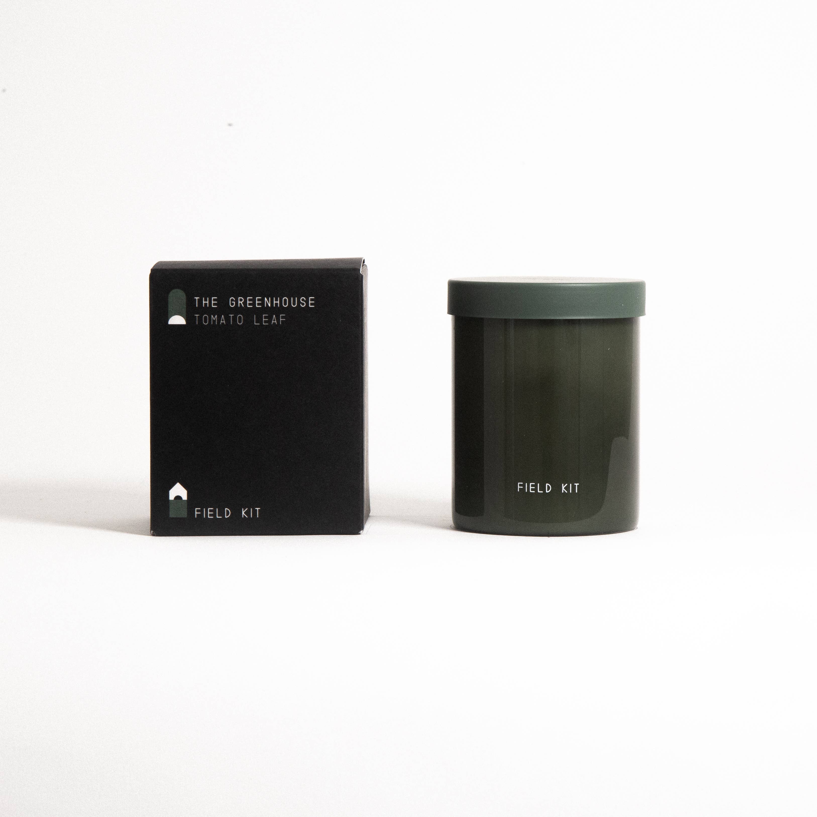 The Greenhouse Candle in a dark green glass jar with its printed box