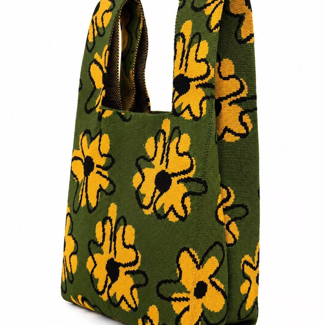 Side view of the golden flower knitted tote bag in moss green, showing its shoulder handles
