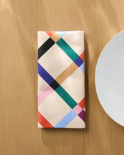 Cool Grid napkin folded lengthways on a wooden table beside a white plate