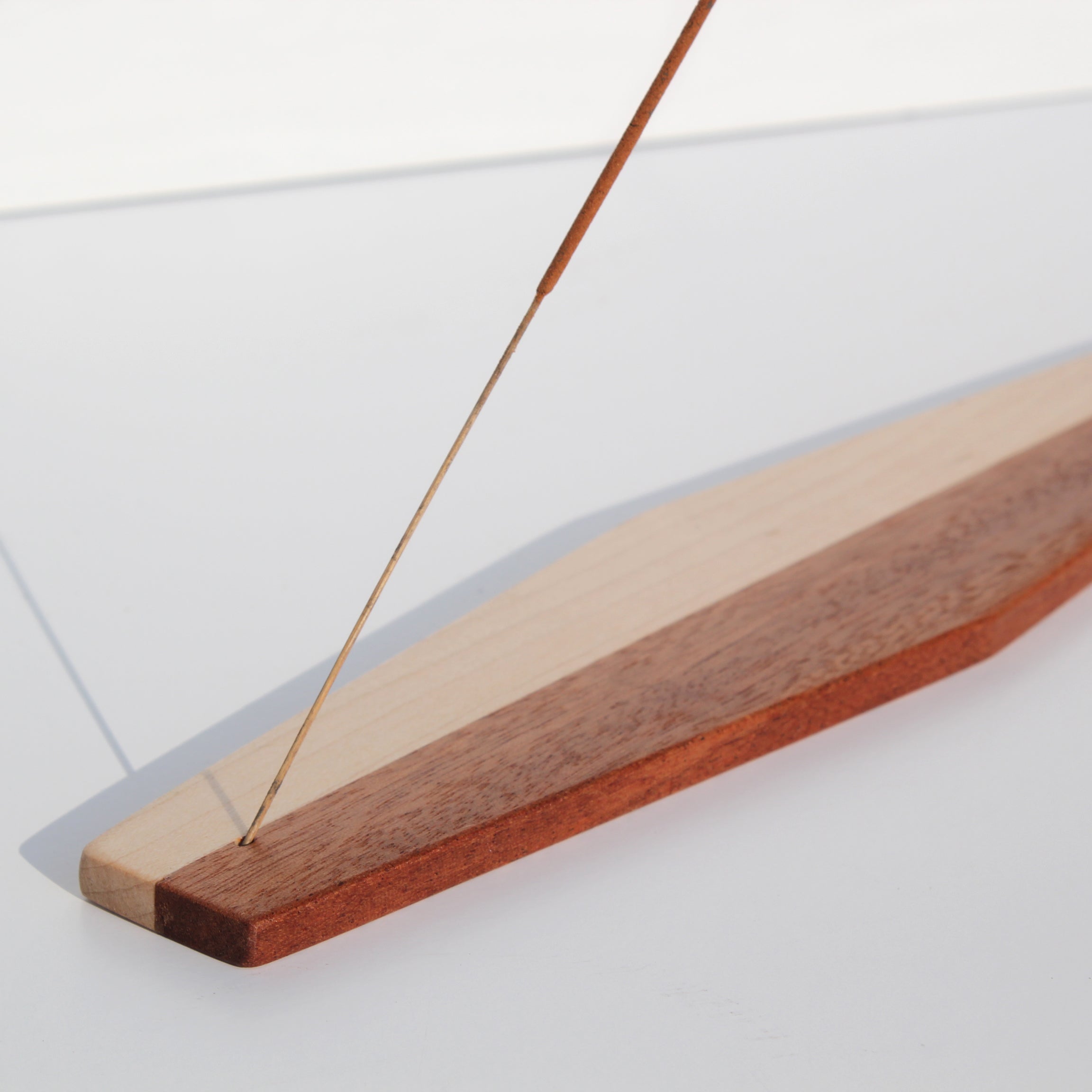 Honeywood Moderna incense holder, a slim plank of banded reclaimed woods with an incense stick in the end
