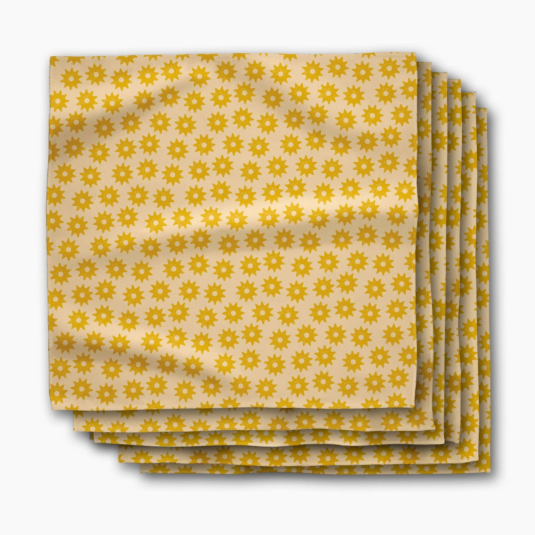 Stack of Sunny Sun dinner napkins, rows of small golden suns on a butter-yellow ground