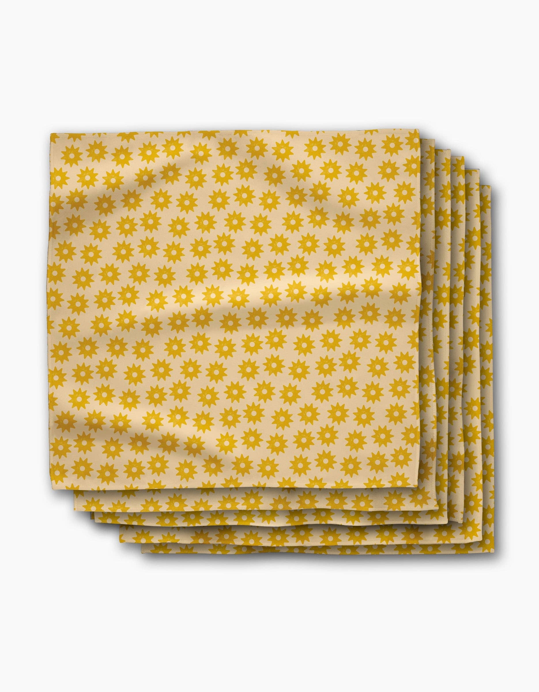 Stack of Sunny Sun dinner napkins, rows of small golden suns on a butter-yellow ground