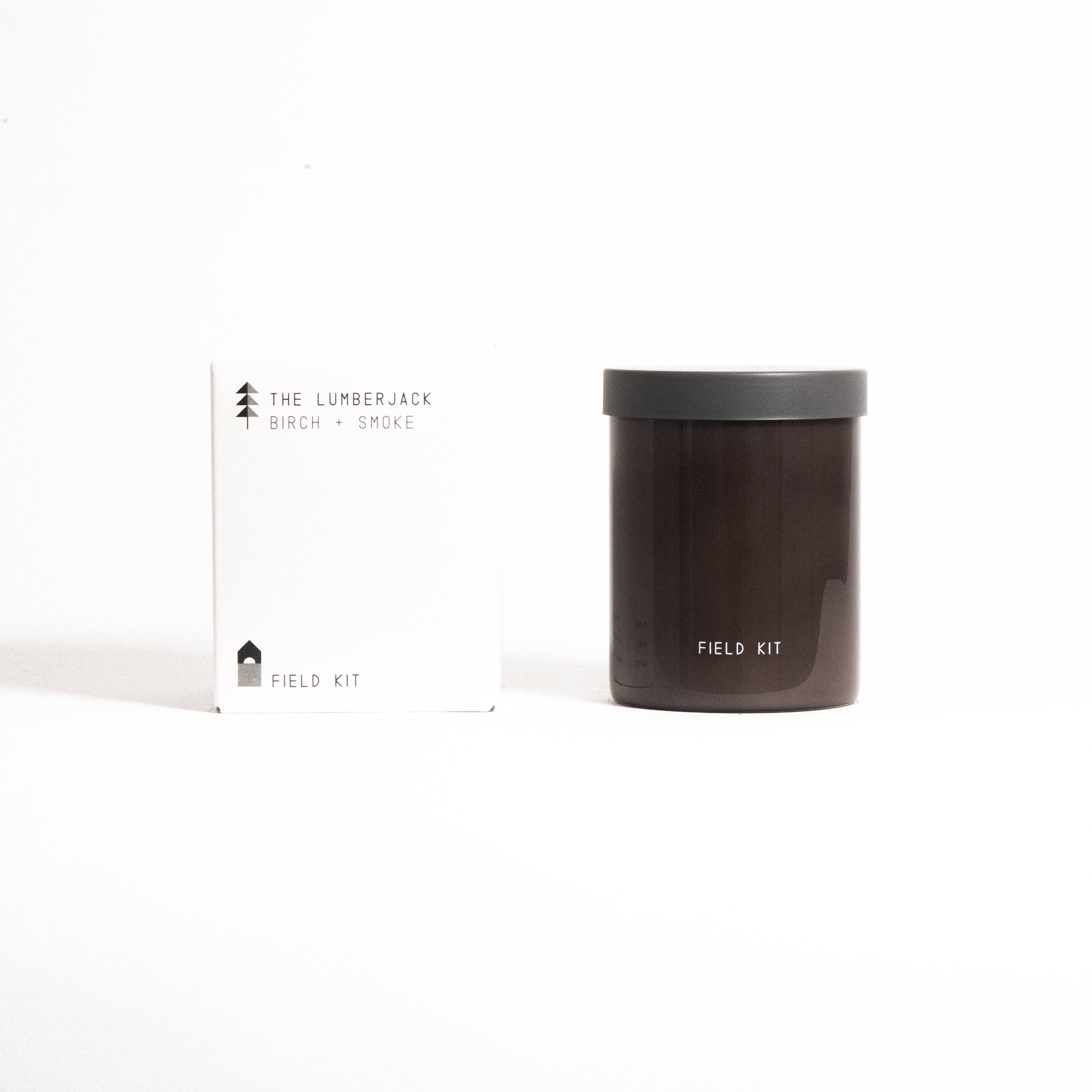 The Lumberjack Candle in a dark brown glass jar with its printed box