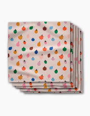 Stack of Fruit Basket dinner napkins, small apples, pears and blossoms on a pale blush ground