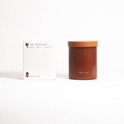 The Professor Candle in a rust glass jar with its printed box