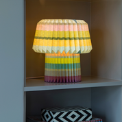 The stripes lamp lit in a white alcove shelf above a patterned box