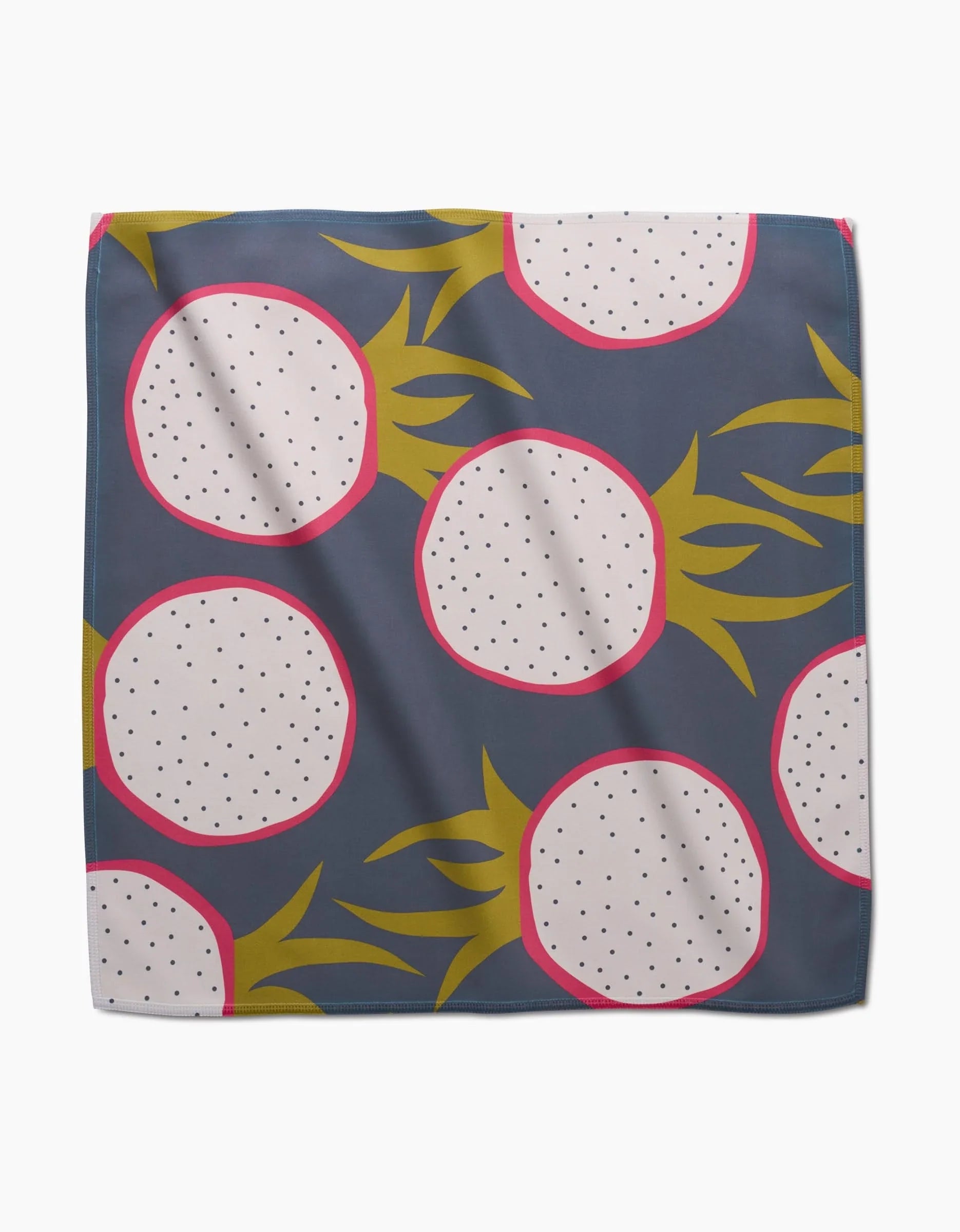 Tropical Fruit napkin laid flat with sliced dragon fruit on a dark slate ground