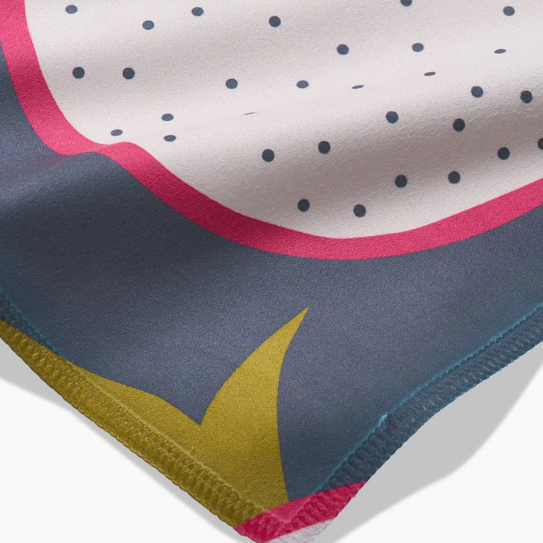 Close-up of the dragon fruit napkin corner, showing the Geosuede weave and stitched hem