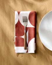 Circle Playground napkin folded on a wooden table with a fork resting on top