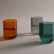 Amber glass tumbler shown alongside the smoke and forest tumblers for color comparison