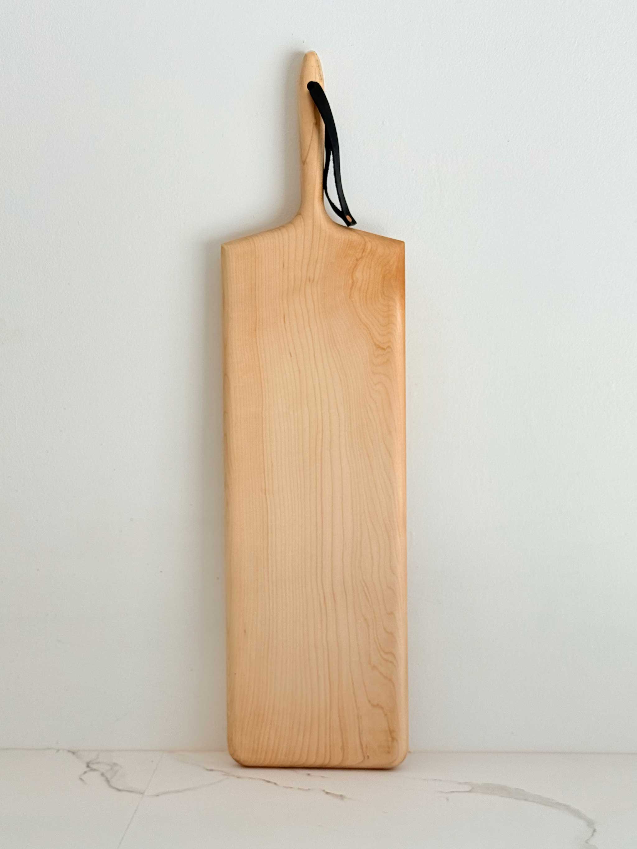 KHEM Studios Monster Board in Maple shown upright with its leather hanging strap