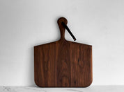 KHEM Studios Norr Board in Walnut standing upright with its leather hanging strap