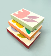 Three flower pads stacked, showing the hand-painted edges in green, orange and red