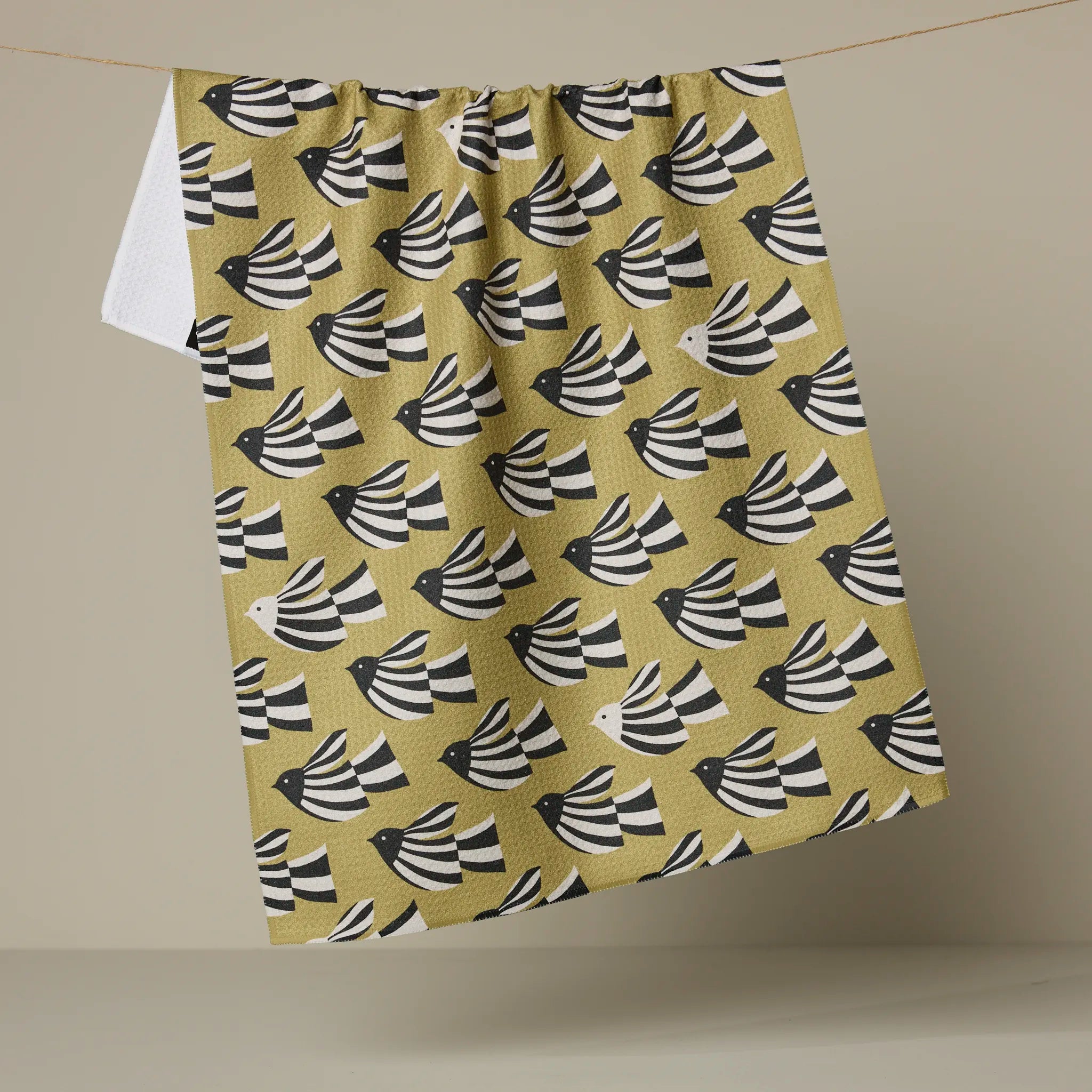 Geometry Alva kitchen tea towel, black and white birds in flight on a mustard ground