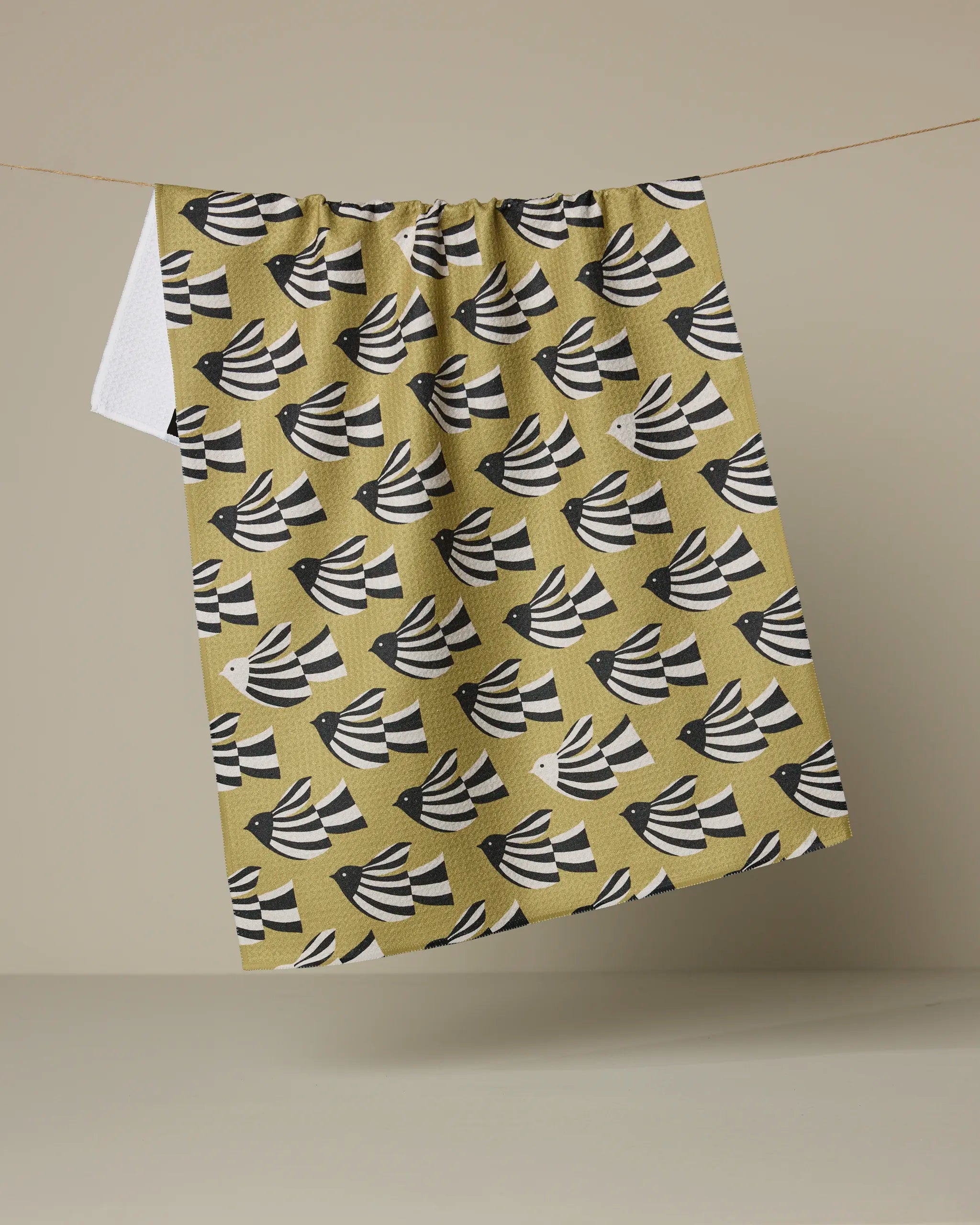 Geometry Alva kitchen tea towel, black and white birds in flight on a mustard ground