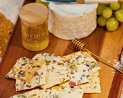 No. 1 crackers on a wooden board with brie, grapes and a jar of Flouwer Co. honey