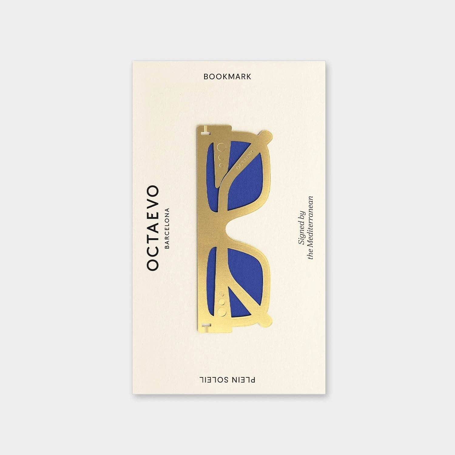 OCTAEVO Plein Soleil bookmark, brass sunglasses shape with blue lenses on its printed card