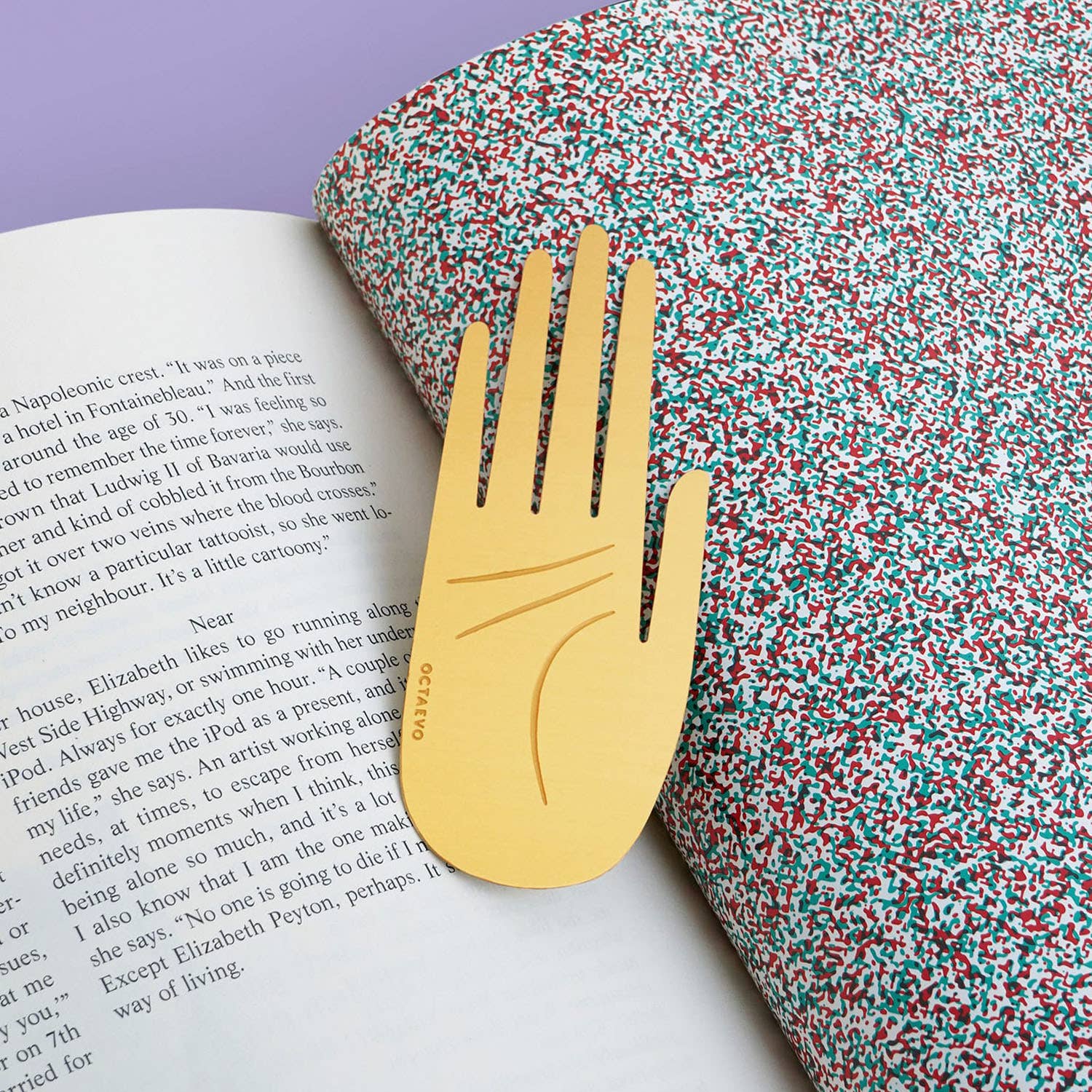 OCTAEVO Hamsa brass bookmark marking a page in an open book