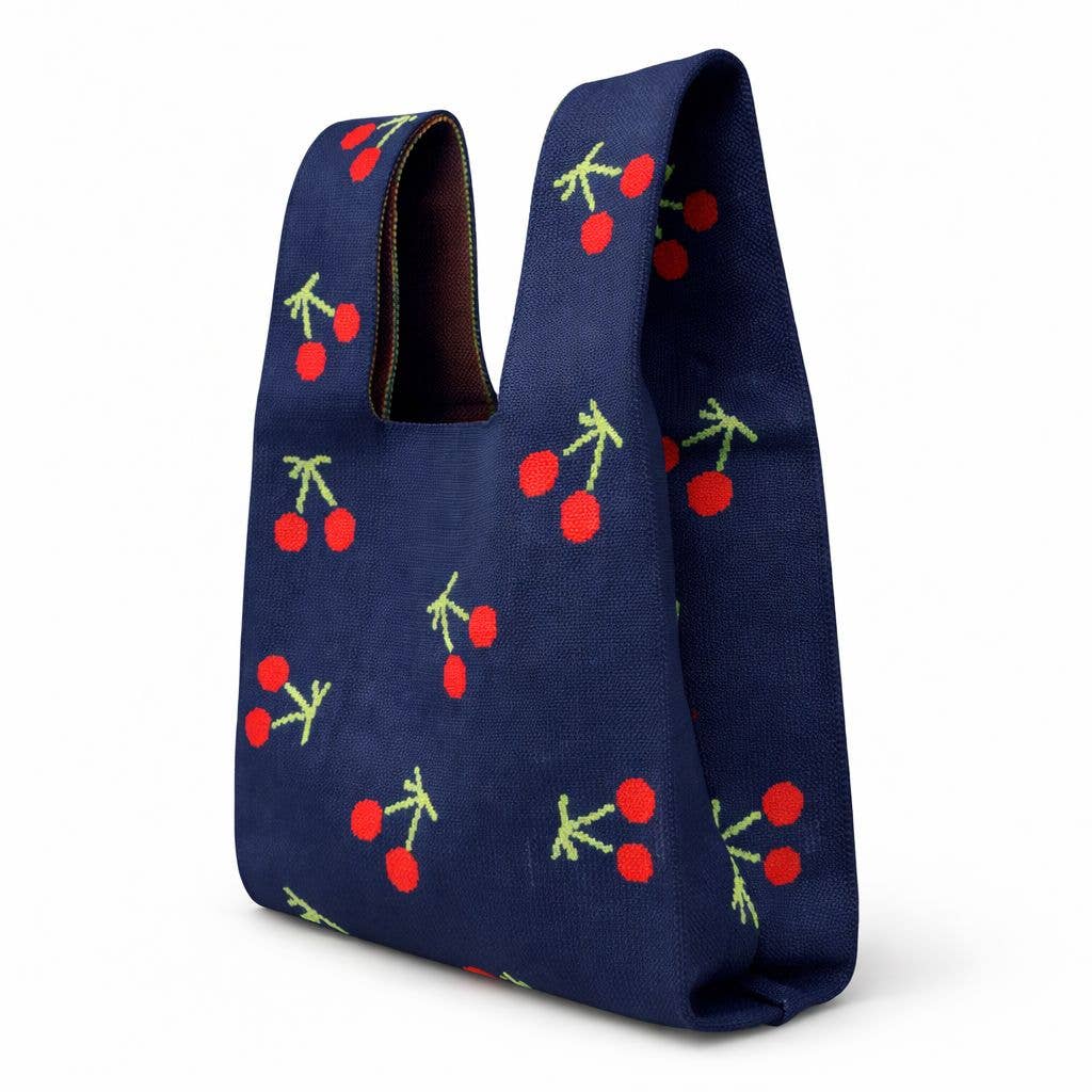Three-quarter view of the navy cherry knitted bag showing its depth and brown lining