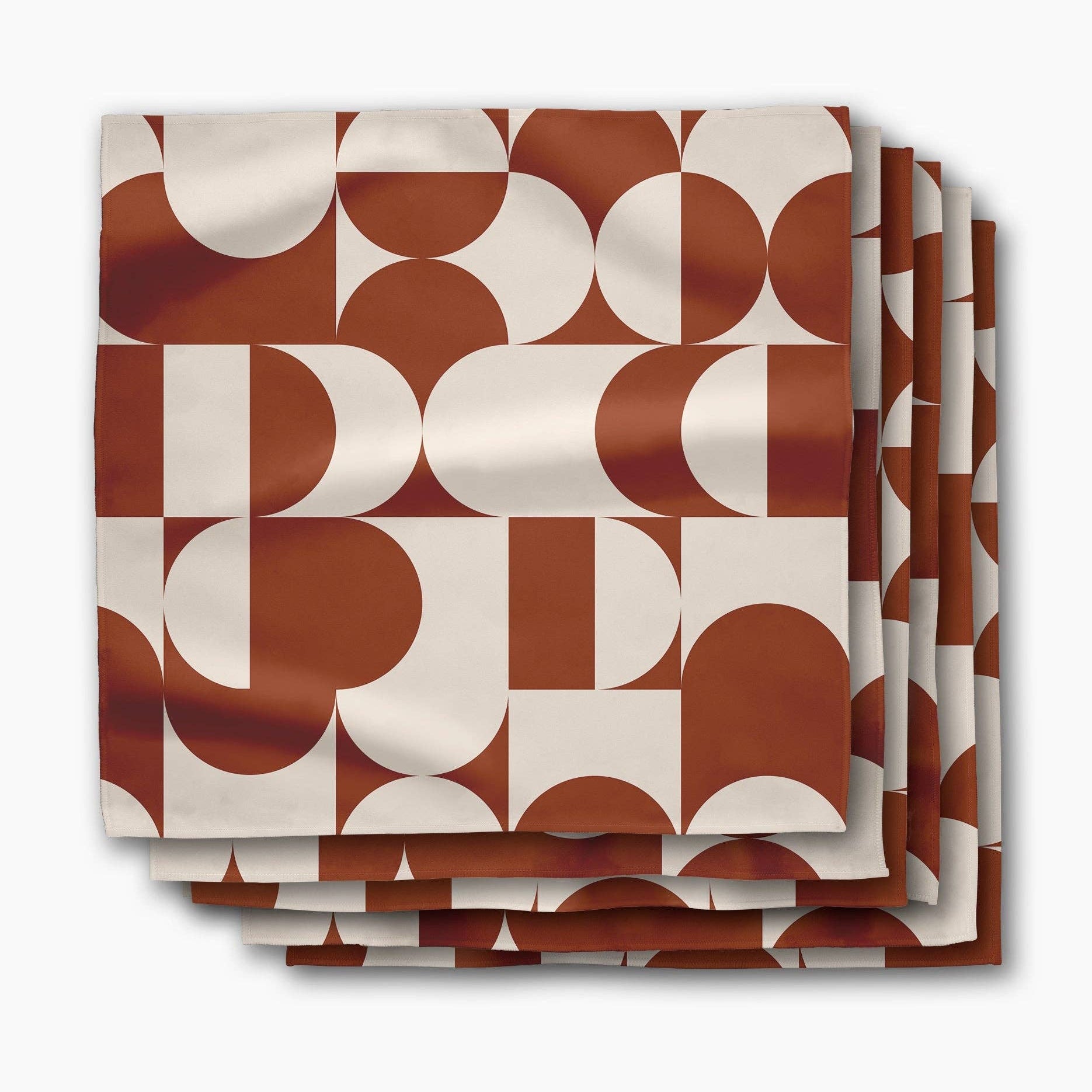Stack of Circle Playground dinner napkins, terracotta and cream half-circles in a mid-century pattern