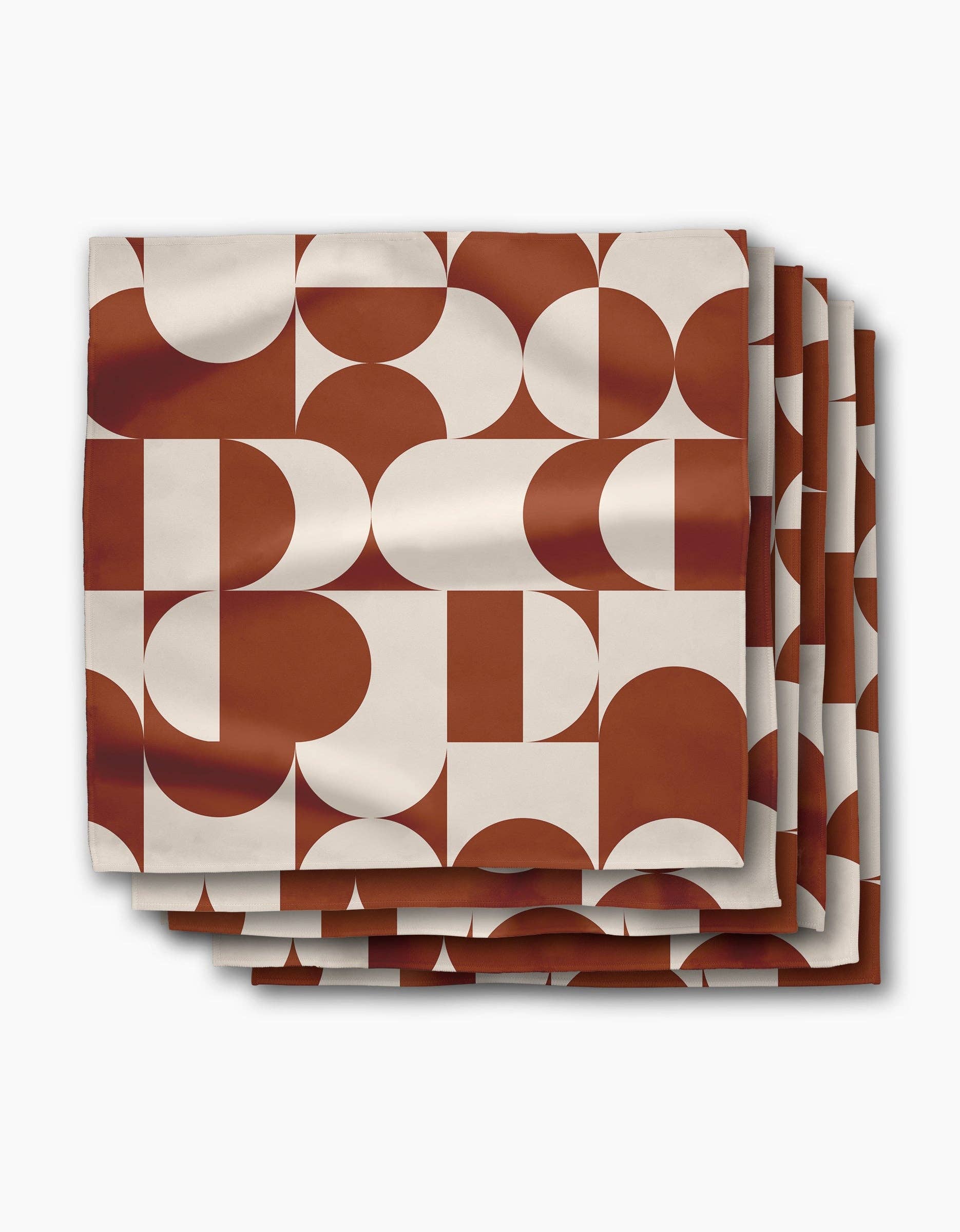 Stack of Circle Playground dinner napkins, terracotta and cream half-circles in a mid-century pattern