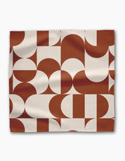 Single Circle Playground napkin laid flat, terracotta and cream half-circles and arcs