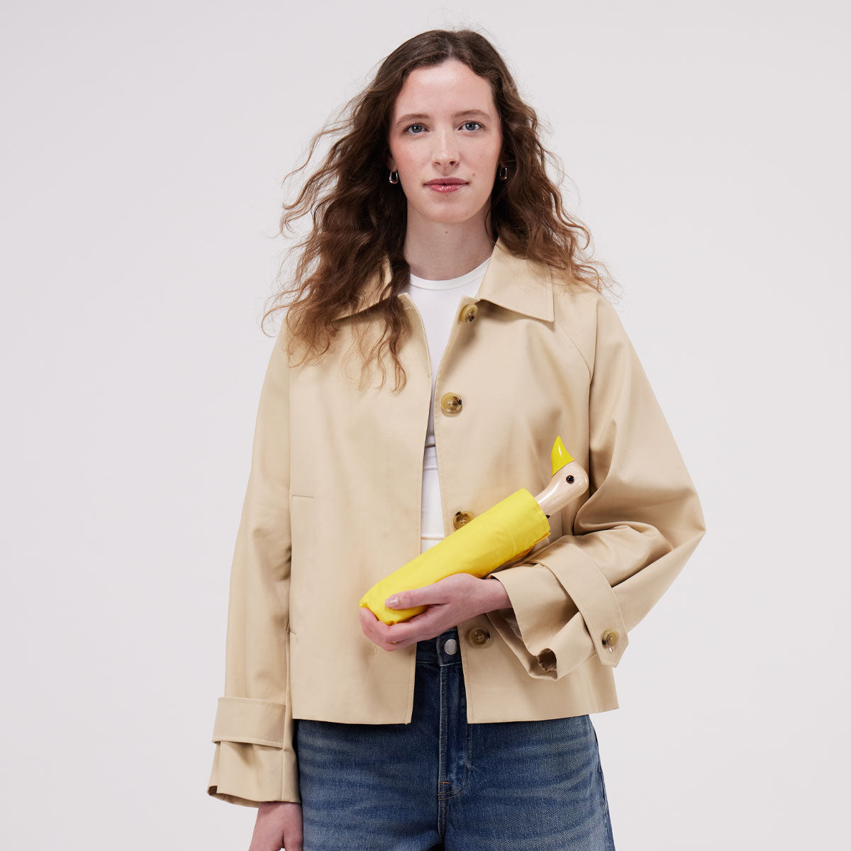 Duck Umbrella closed in its matching storage sleeve, held in hand to show the compact size
